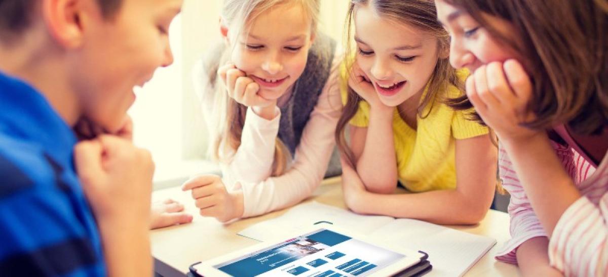 Niños alrededor de una Tablet.
