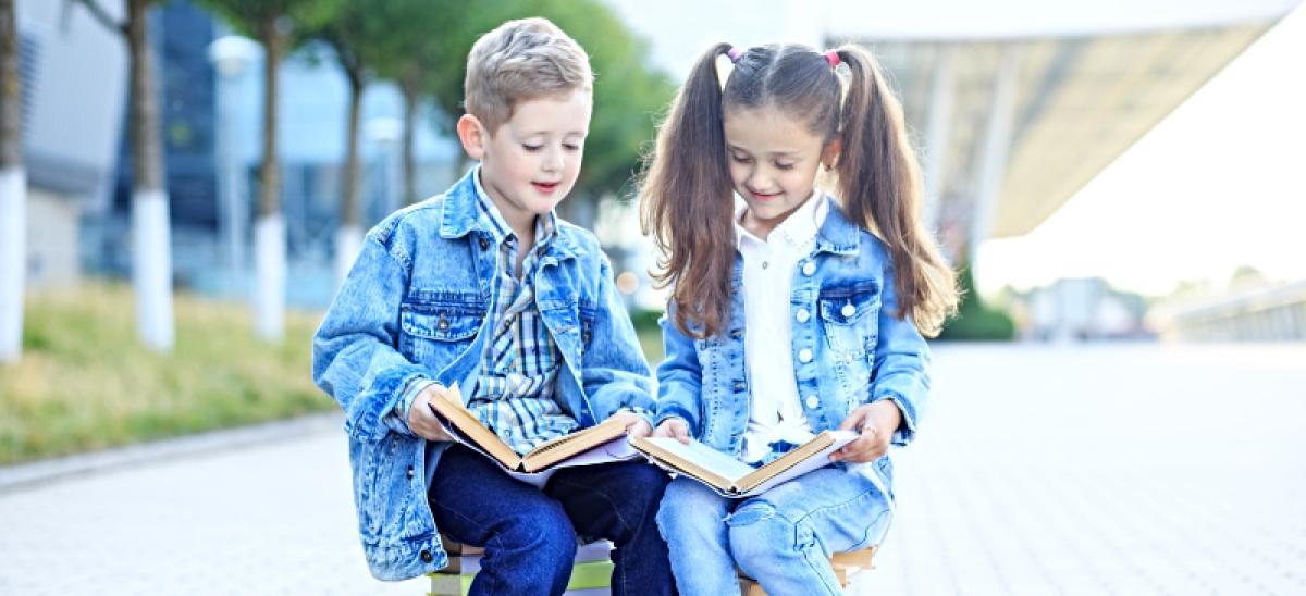 Niños leyendo en un parque.