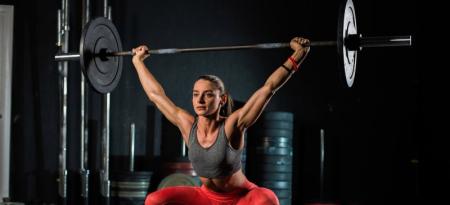 Mujer ejercitándose con pesas en un gimnasio.